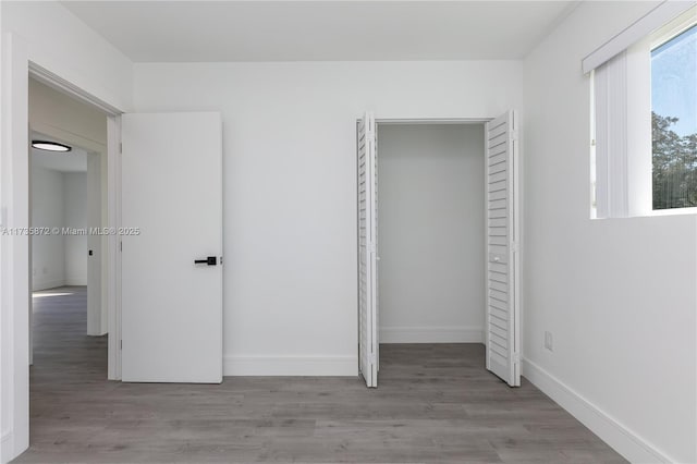 unfurnished bedroom with a closet and light hardwood / wood-style flooring