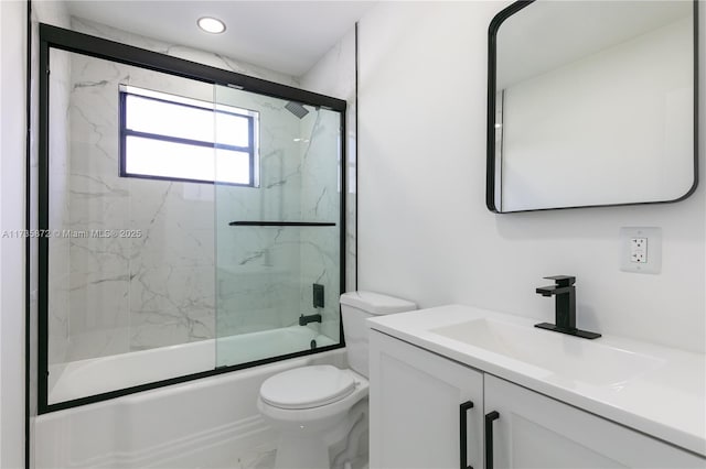 full bathroom featuring vanity, combined bath / shower with glass door, and toilet