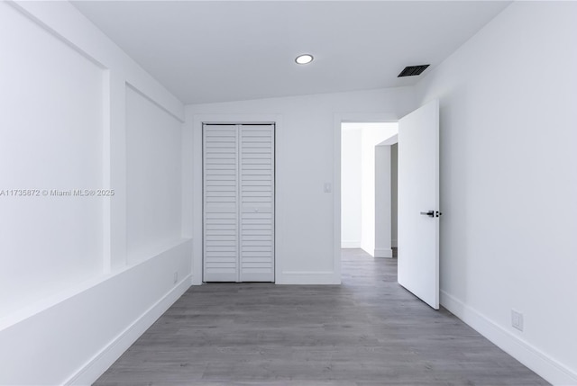 unfurnished bedroom with dark wood-type flooring and a closet