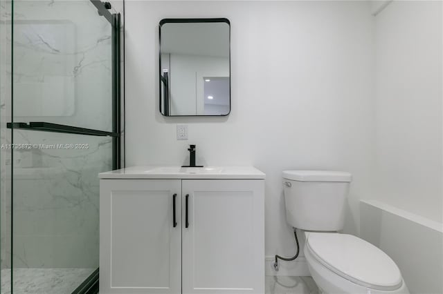 bathroom featuring vanity, a shower with shower door, and toilet