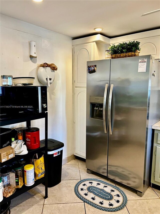 kitchen featuring light tile patterned flooring, white cabinets, and stainless steel refrigerator with ice dispenser