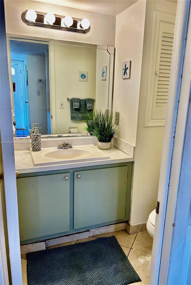 bathroom with tile patterned flooring, vanity, and toilet