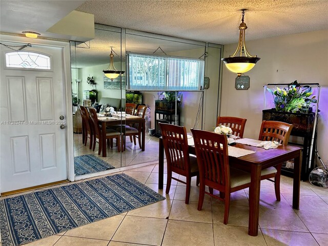 tiled dining room featuring a textured ceiling