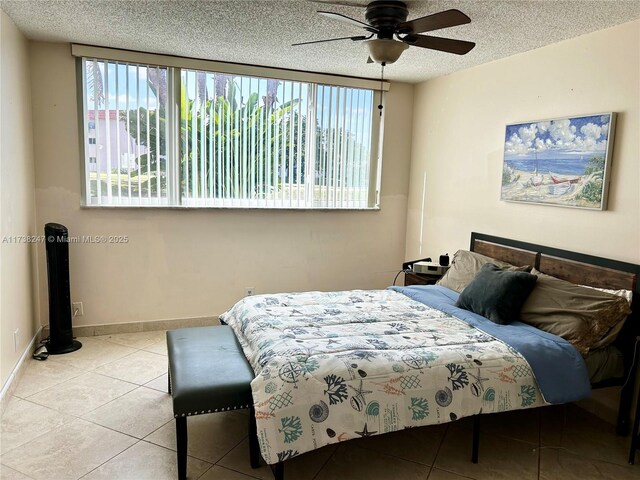 bedroom with multiple windows, light tile patterned floors, a textured ceiling, and ceiling fan