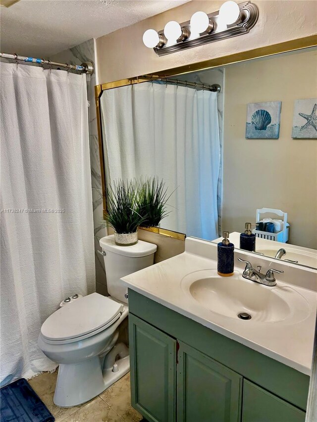 bathroom with tile patterned floors, vanity, toilet, and a textured ceiling