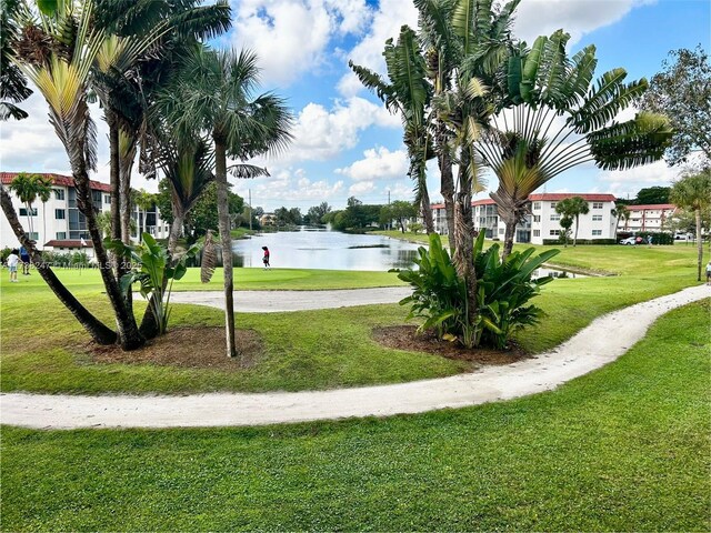 view of home's community featuring a lawn and a water view