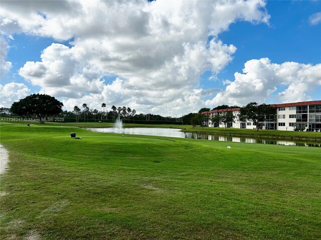 view of property's community featuring a lawn and a water view