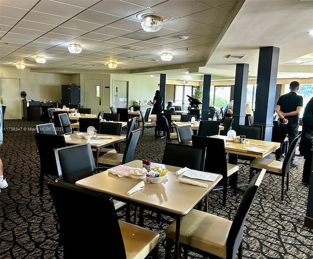 dining room with a drop ceiling and carpet