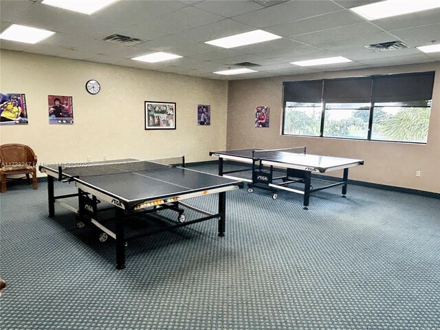 game room with a drop ceiling and carpet flooring