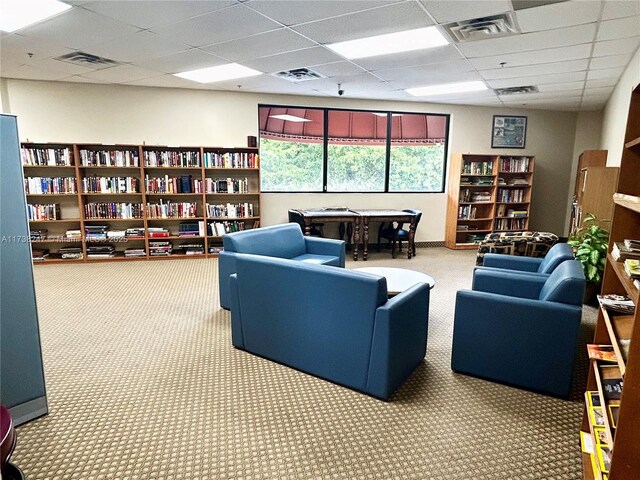 carpeted office space with a paneled ceiling