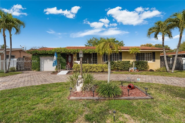 single story home featuring a garage and a front lawn