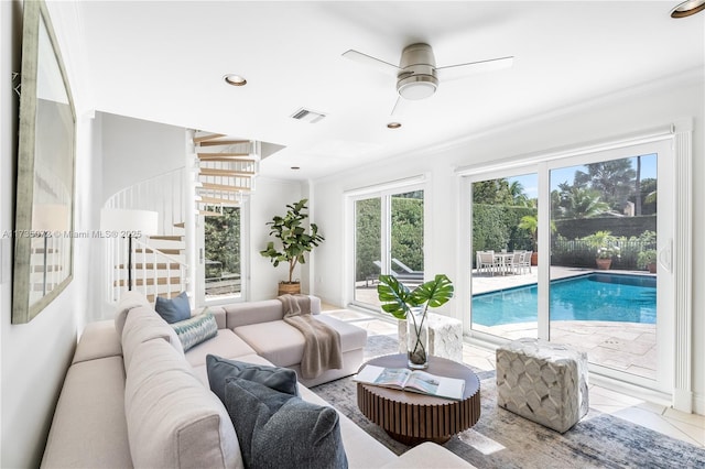 living room with ornamental molding, light tile patterned floors, and ceiling fan