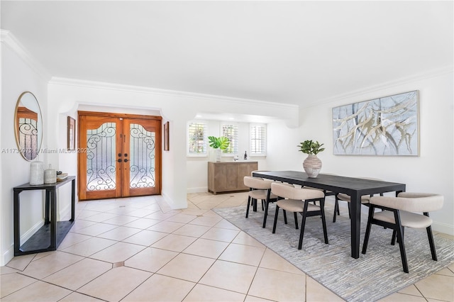 dining space with light tile patterned flooring, ornamental molding, and french doors