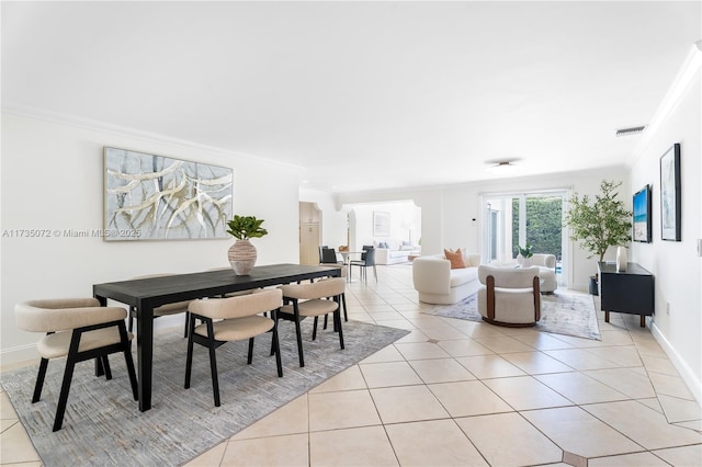 dining area with light tile patterned flooring and ornamental molding