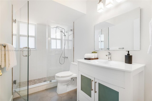 bathroom featuring vanity, toilet, tile patterned flooring, and a shower with door