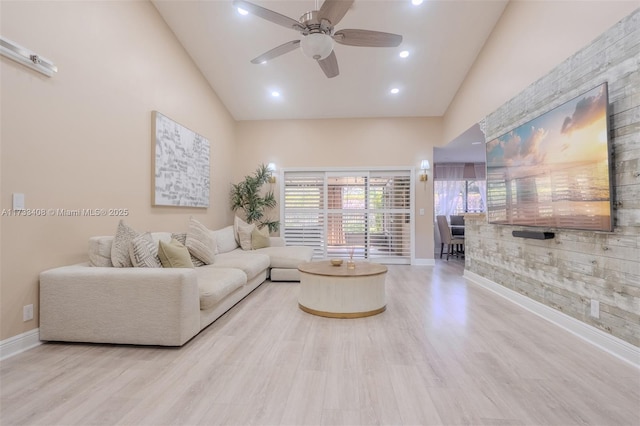 living room with ceiling fan, high vaulted ceiling, and light wood-type flooring