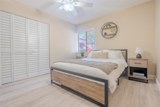 bedroom featuring ceiling fan, a closet, and light wood-type flooring