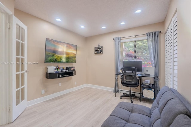 office with light hardwood / wood-style flooring and a textured ceiling