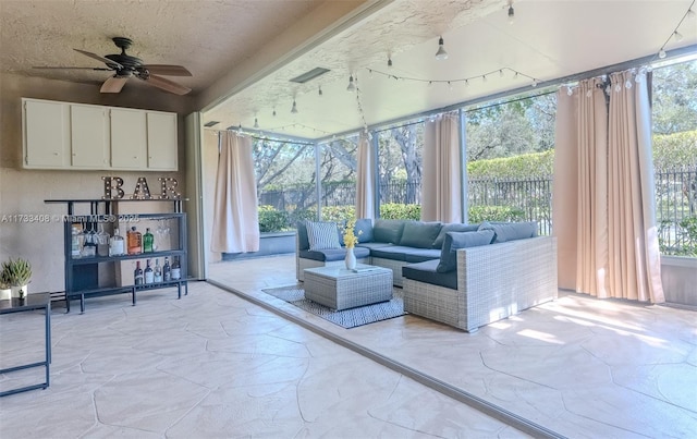 sunroom with plenty of natural light and ceiling fan