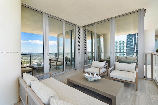 living area featuring light wood-type flooring, floor to ceiling windows, and a view of city