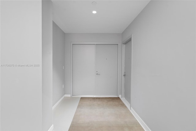 hall with baseboards and recessed lighting