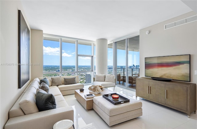 living area featuring expansive windows, light tile patterned floors, and visible vents