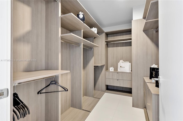 walk in closet with light tile patterned floors