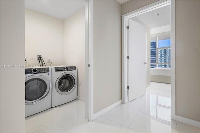 laundry area with laundry area, baseboards, separate washer and dryer, and tile patterned floors