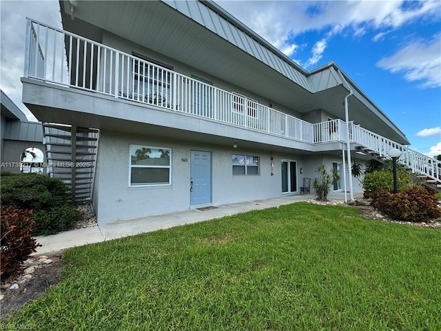 6777 Winkler Rd Unit A160, Fort Myers, FL 33919 - rear view of house featuring a lawn, a balcony, stucco siding, and stairs