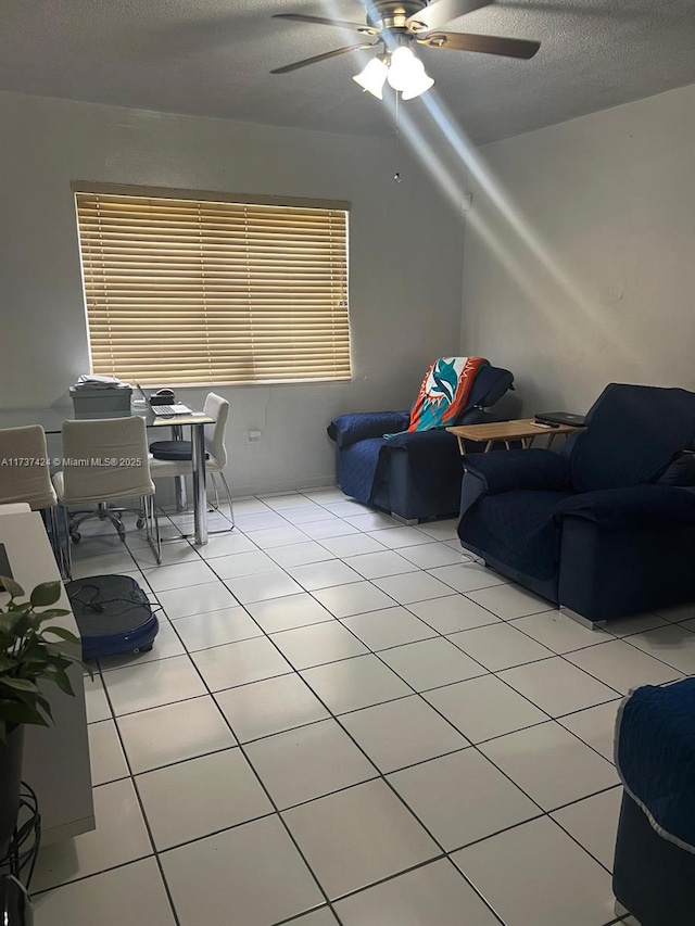 tiled living room with ceiling fan and a textured ceiling