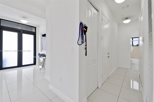 hallway featuring light tile patterned floors and french doors