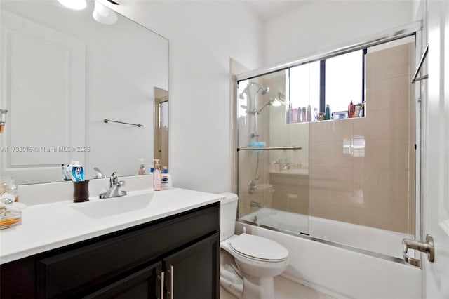 full bathroom featuring vanity, bath / shower combo with glass door, and toilet