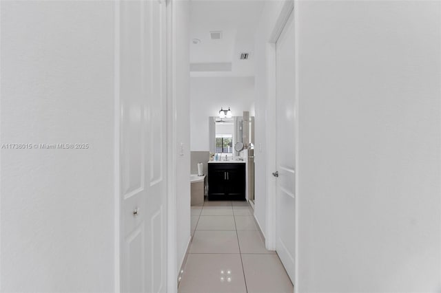 hall with light tile patterned flooring and sink