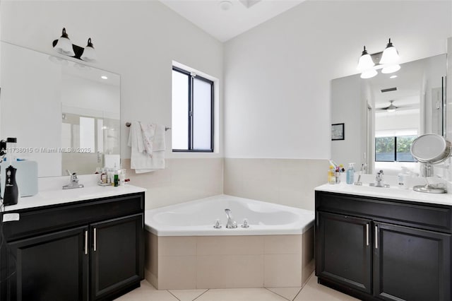 bathroom with tile patterned floors, vanity, and tiled bath