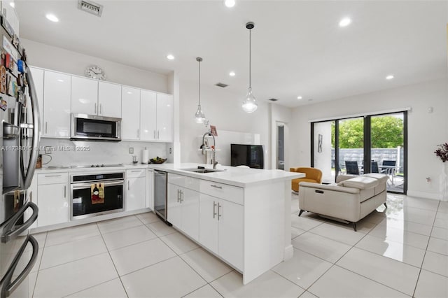 kitchen featuring sink, white cabinetry, decorative light fixtures, appliances with stainless steel finishes, and kitchen peninsula