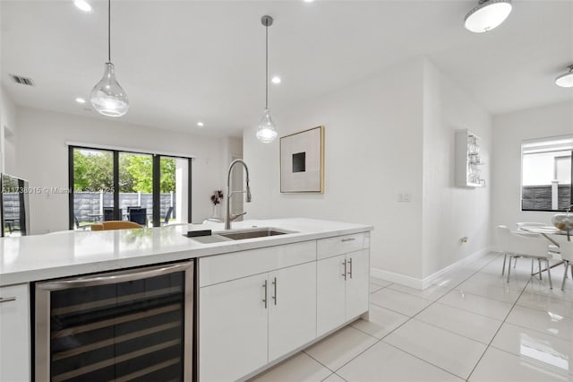 kitchen featuring white cabinets, light tile patterned flooring, hanging light fixtures, and wine cooler