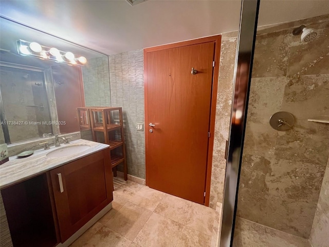 bathroom with vanity and a tile shower