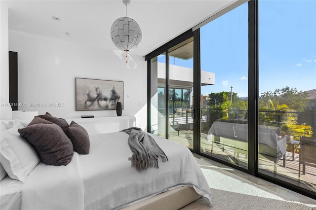 bedroom featuring access to exterior and floor to ceiling windows