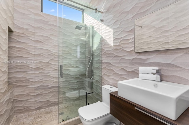 bathroom featuring walk in shower, tile walls, vanity, and toilet