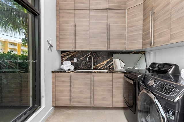 laundry area featuring cabinets, independent washer and dryer, and sink