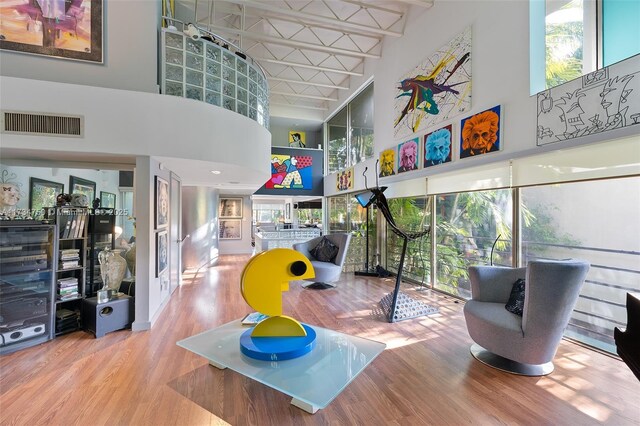 interior space with a towering ceiling and wood-type flooring