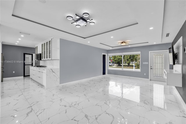 unfurnished living room featuring a tray ceiling