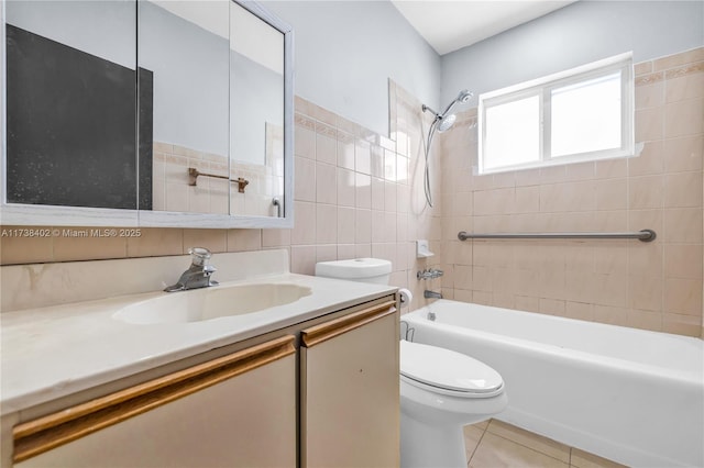 full bathroom with tile patterned floors, toilet, tile walls, vanity, and tiled shower / bath combo