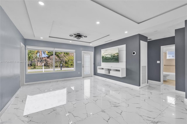 unfurnished living room featuring a raised ceiling