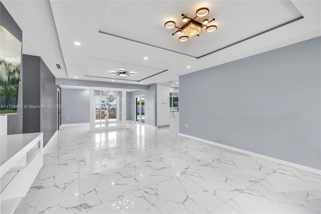 unfurnished living room with french doors and a tray ceiling