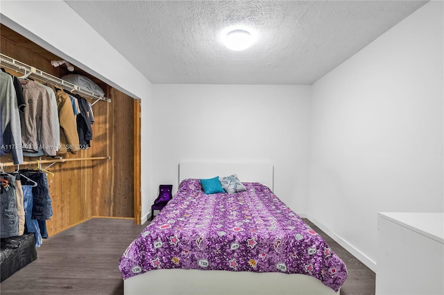 bedroom featuring dark wood-type flooring and a textured ceiling