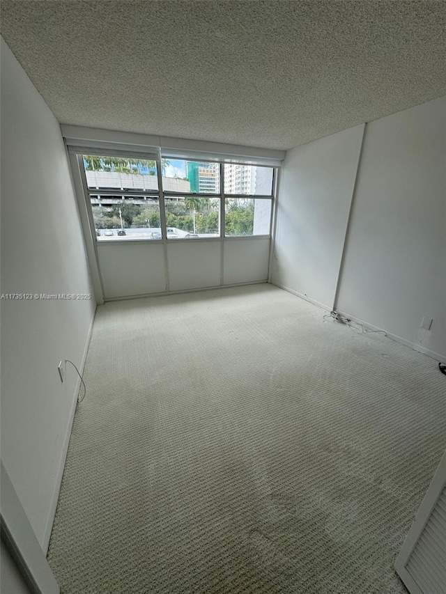 carpeted empty room with a textured ceiling