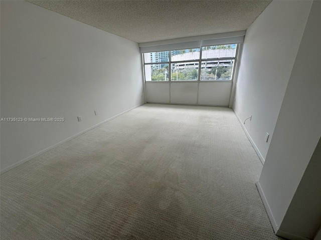 empty room with carpet floors and a textured ceiling