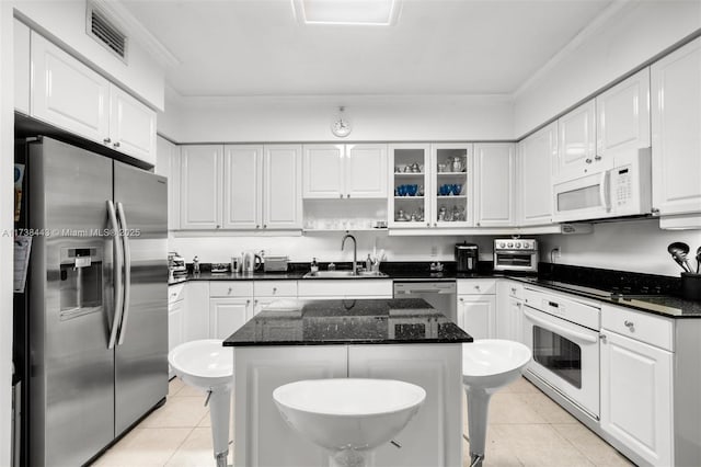 kitchen with a kitchen island, appliances with stainless steel finishes, sink, and white cabinets