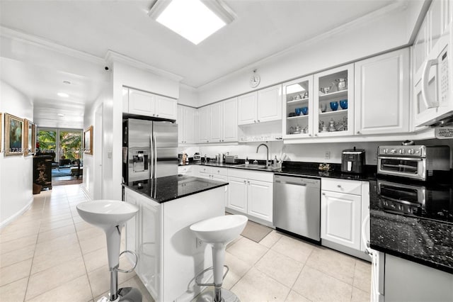 kitchen featuring appliances with stainless steel finishes, white cabinetry, sink, a kitchen breakfast bar, and light tile patterned floors